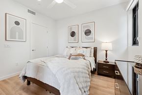 San Diego apartment for rent - OnyxOnPark_SanDiego_CA_Model_1BR_ A bedroom with a large bed and two framed pictures on the wall.