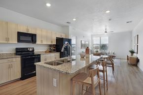 American Fork apartment for rent - Alvera at the Meadows kitchen with wooden cabinets and a granite countertop.
