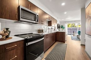 Seattle apartment for rent - A modern kitchen with dark wood cabinets and a black stove top oven.