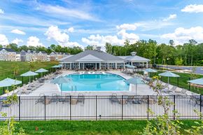 White Plains apartment for rent - A large swimming pool surrounded by a black fence and a pavilion with a grey roof.