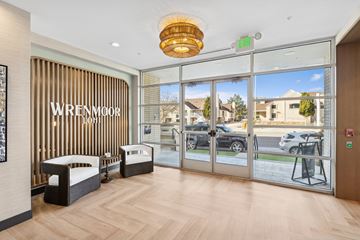 Denver apartment for rent - A reception area with a glass door and a sign that says Wrenmoor.