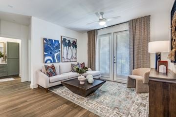 Mckinney apartment for rent - A living room with a white couch, a coffee table, and a painting on the wall.