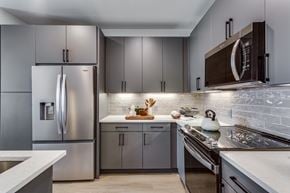 Lewisville apartment for rent - A modern kitchen with a stainless steel refrigerator and a white countertop.
