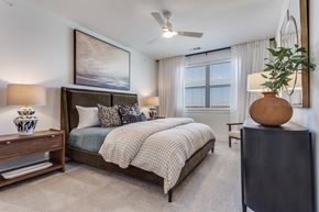 Lewisville apartment for rent - A bedroom with a large bed and a ceiling fan.
