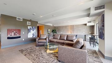 Denver apartment for rent - A living room with a brown couch and a glass coffee table.