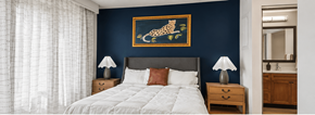 Houston apartment for rent - A bedroom with a white bed and a painting of a leopard on the wall.