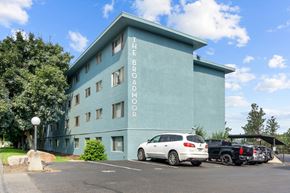 Spokane apartment for rent - The Broadmoor building has a parking lot in front of it.