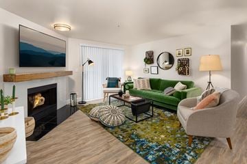 Everett apartment for rent - A living room with a fireplace, a green couch, and a painting on the wall.