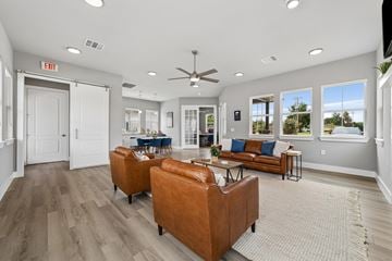 Gunter apartment for rent - A living room with a brown leather couch and a ceiling fan.