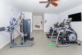 Tucson apartment for rent - A gym with a row of treadmills and a weight machine.