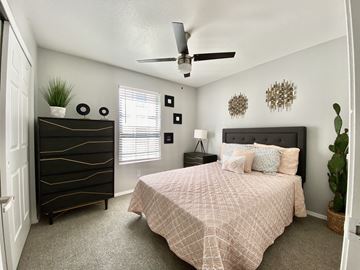 Tucson apartment for rent - A bedroom with a bed, dresser, and ceiling fan.