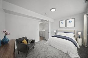 Gillette apartment for rent - a bedroom with a medium sized bed and a chair in front of a window