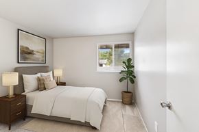 Gresham apartment for rent - A bedroom with a bed, nightstands, and a plant.
