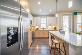 Winter Garden apartment for rent - A modern kitchen with a stainless steel refrigerator and wooden flooring.