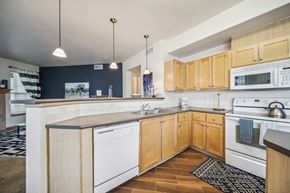 Richland apartment for rent - A kitchen with wooden cabinets and white appliances.