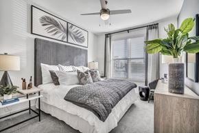 Grand Prairie apartment for rent - A bedroom with a large bed and a ceiling fan.