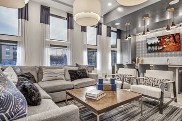 Grand Prairie apartment for rent - A modern living room with a grey sofa, a wooden coffee table, and a large painting on the wall.