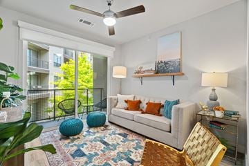 San Antonio apartment for rent - A living room with a couch, a chair, a rug, and a painting on the wall.