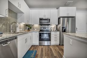 North Richland Hills apartment for rent - A modern kitchen with white cabinets and stainless steel appliances.