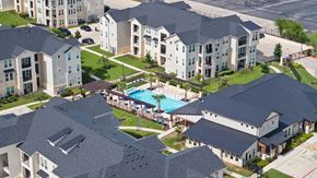 San Antonio apartment for rent - A bird's eye view of a residential area with houses and a swimming pool.