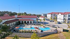 Austin apartment for rent - A large building with a pool in front of it.