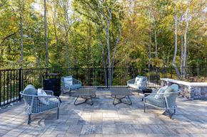 Charlotte apartment for rent - A patio with a table and chairs surrounded by trees.