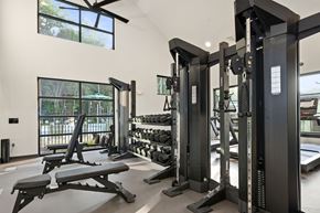 Charlotte apartment for rent - Axis at the park gym with a row of black weight machines.