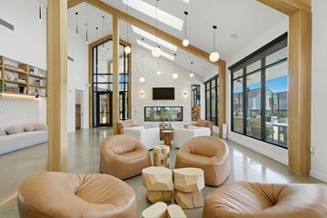 Spring townhouse for rent - A modern living room with leather chairs and a television.