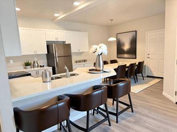 Sacramento apartment for rent - A kitchen with brown chairs and a white counter.