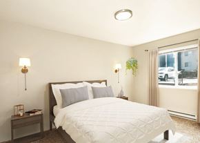 Portland apartment for rent - A bedroom with a large bed and a window overlooking a street.