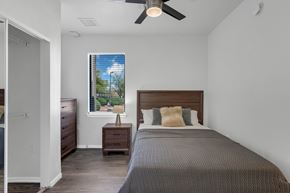 Tucson apartment for rent - A bedroom with a bed, nightstand, and window.