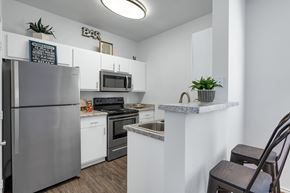 Tucson apartment for rent - A kitchen with a refrigerator, stove, and microwave.