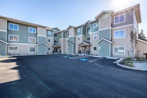 Wenatchee apartment for rent - A sunny day at a large apartment complex with a parking lot in front.