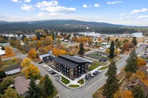 Post Falls apartment for rent - A large building with a parking lot in front of it.
