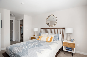 Tualatin apartment for rent - A bedroom with a bed, two lamps, and a mirror on the wall.