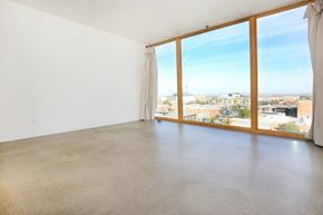 Tucson apartment for rent - A large empty room with a view of the cityscape outside the window at Herbert Residential, Tucson
