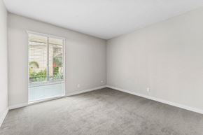 San Diego apartment for rent - A room with a window and a view of a building and trees outside.