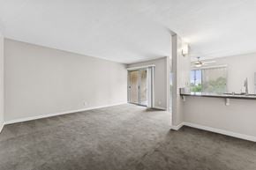 San Diego apartment for rent - A spacious room with a carpeted floor and a sliding glass door leading to a balcony.