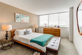 Chicago apartment for rent - a bedroom with a bed and a dresser and two windows