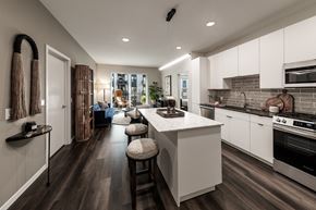 Aurora apartment for rent - A modern kitchen with white cabinets and a central island.