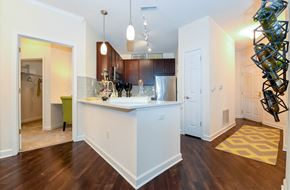 Wauwatosa apartment for rent - a kitchen with an island and a living room with a refrigerator and a sink