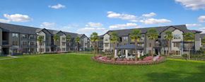 Davenport apartment for rent - A large building complex with a green lawn in front and a circular flower bed in the middle.