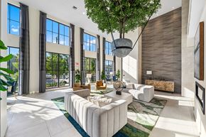 Palmetto Bay apartment for rent - a spacious living room with large windows and a tree in the middle