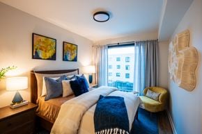 Atlanta apartment for rent - A bedroom with a large bed and a yellow chair.