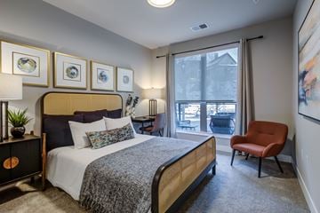 Milwaukee apartment for rent - A bedroom with a bed, chair, and pictures on the wall.
