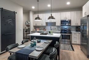 Aurora apartment for rent - a kitchen and dining room with stainless steel appliances and a table