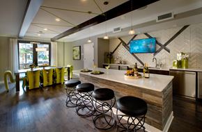 Atlanta apartment for rent - Community kitchen with kitchen island, mini fridge, long table, and a large window. 