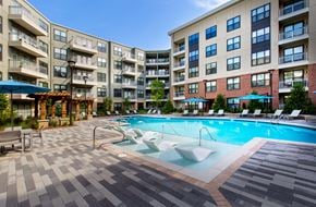 Atlanta apartment for rent - Outdoor pool area with multiple lounge chairs and shaded seating areas. 