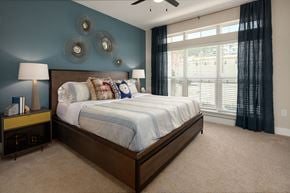 Johns Creek apartment for rent - A bedroom with a large bed and a ceiling fan.