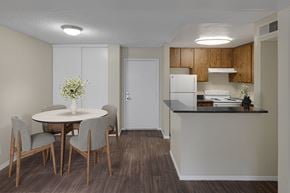 Las Vegas apartment for rent - Wood-style vinyl plank floored dining room and kitchen with virtually staged table and chairs.
